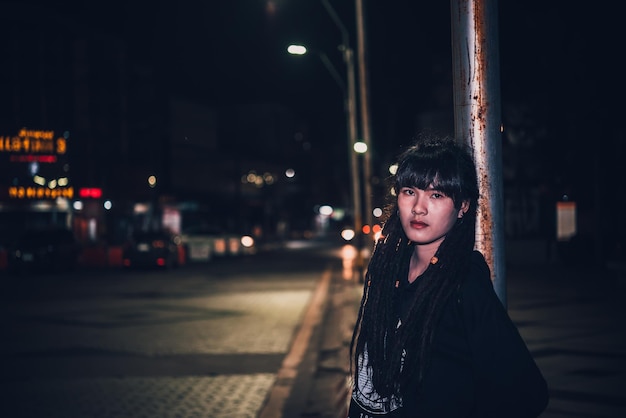 Retrato de mujer asiática cabello dreadlock escena nocturna en la ciudad La gente de Tailandia posan para tomar una foto sintiendo el concepto de mujer sola y triste