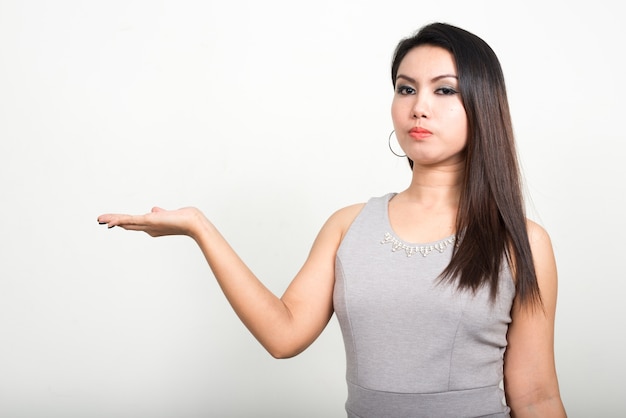 Retrato de mujer asiática contra la pared blanca