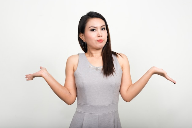 Retrato de mujer asiática contra la pared blanca