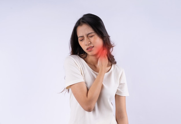 Retrato de mujer asiática con dolor de cuello aislado sobre fondo blanco.