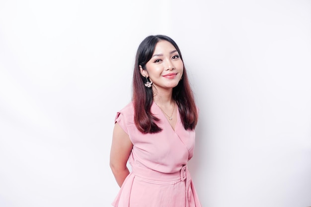 Un retrato de una mujer asiática feliz con una blusa rosa aislada de fondo blanco