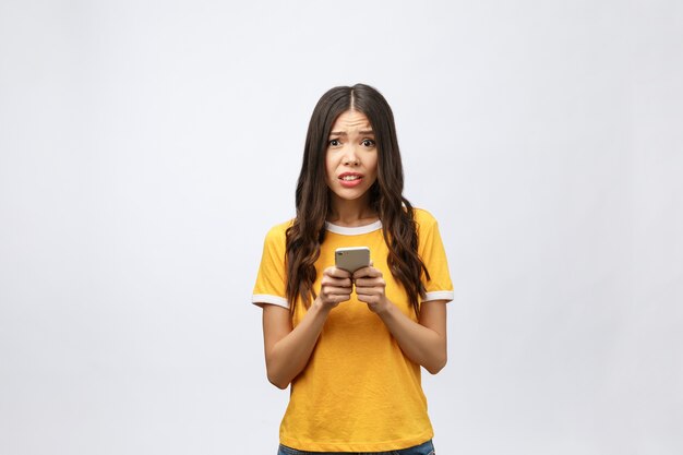 Retrato de una mujer asiática furiosa hablando por móvil