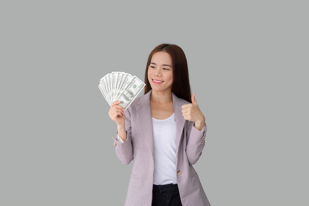 Retrato de mujer asiática hermosa sonriente con muchos billetes de dinero