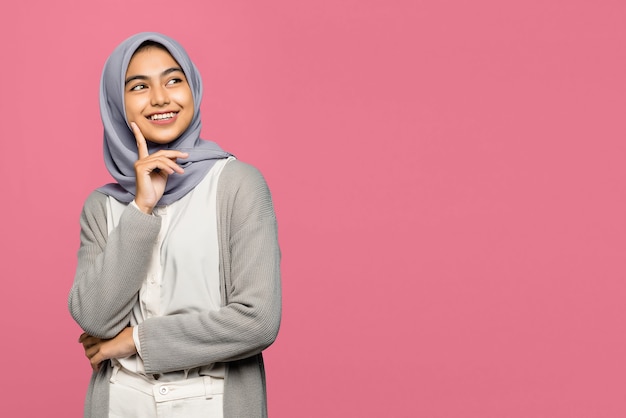 Retrato de mujer asiática joven sonriente mirando hacia arriba y toca su mejilla