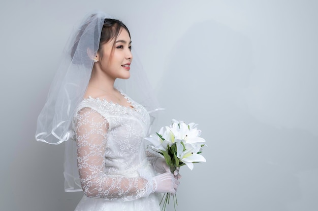 Retrato de mujer asiática llevar novia con flor sobre fondo blancoConcepto de boda