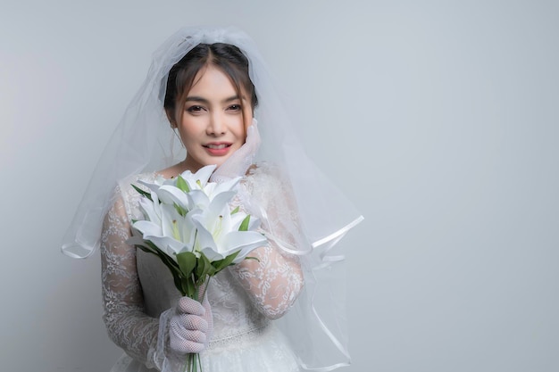 Retrato de mujer asiática llevar novia con flor sobre fondo blancoConcepto de boda