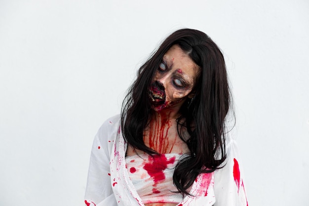 Retrato de mujer asiática maquillada cara de fantasma con sangre sobre fondo blancoEscena de terrorFondo aterradorCartel de HalloweenGente de Tailandia