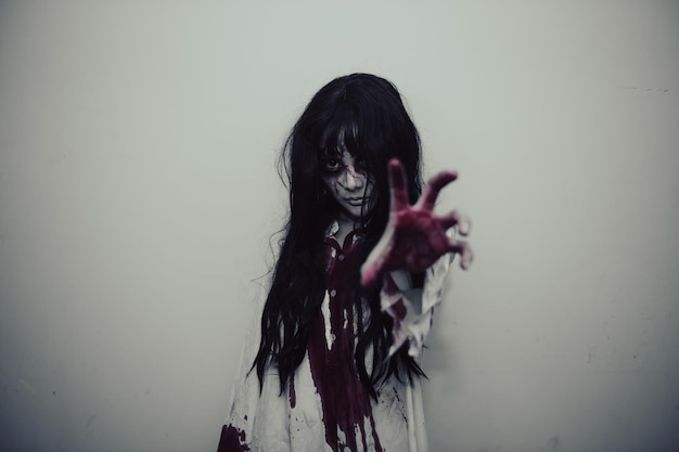 Foto retrato de mujer asiática maquillaje fantasmaescena de terror aterradora para el fondoconcepto del festival de halloweencartel de películas fantasmaespíritu enojado en el apartamento