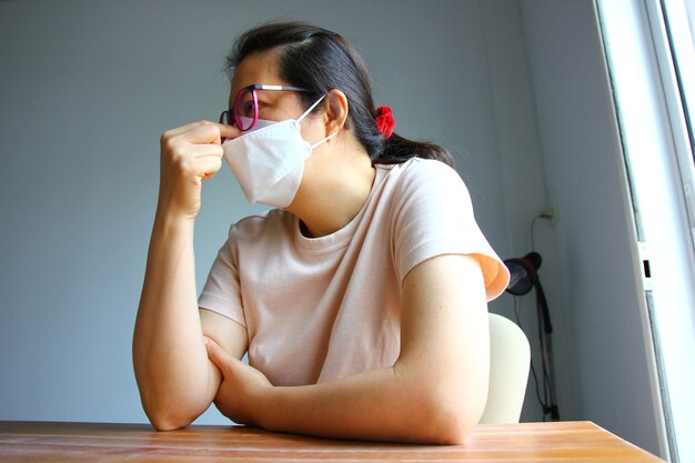 Retrato de mujer asiática con máscara en un momento triste en el brote de virus durante mucho tiempo