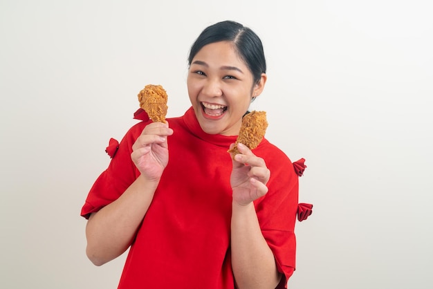 Retrato mujer asiática con pollo frito en la mano