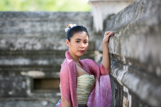 Retrato de una mujer asiática en ropa tradicional tailandesa Lanna y Shan están de pie junto a la pared