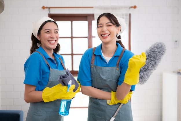 Foto retrato de una mujer asiática del servicio de limpieza en uniforme y guantes de goma concepto de trabajo doméstico