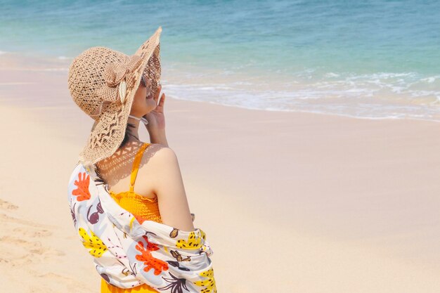 Retrato de mujer asiática sonriente feliz en la playa en una hermosa chica bonita asiática en casual mirando hacia otro lado y sonriendo riendo La playa hermosa en el cielo brillante