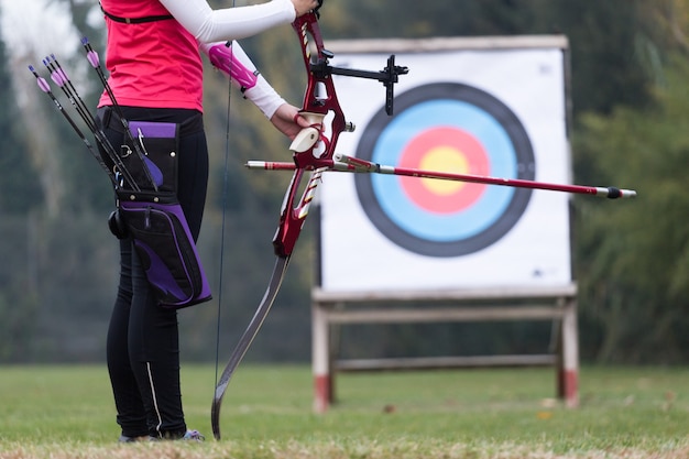 Foto retrato de mujer atleta practicando tiro con arco en el estadio.