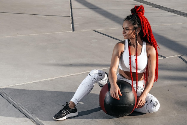 Retrato Mujer atlética haciendo ejercicio con pelota médica Fuerza y motivaciónFoto de mujer deportiva en ropa deportiva de moda