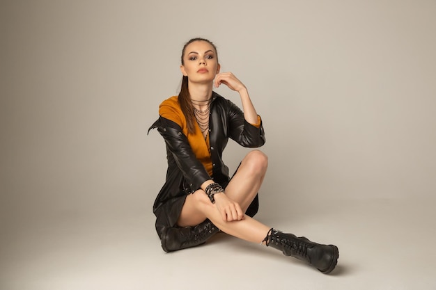 Retrato de mujer atractiva joven caucásica posando en un piso blanco en estudio blanco. Pruebas de modelo de niña bonita en ciclorama.