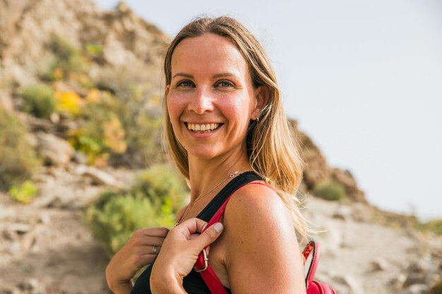 Retrato de una mujer atractiva sonriendo mientras hace una caminata en la naturaleza