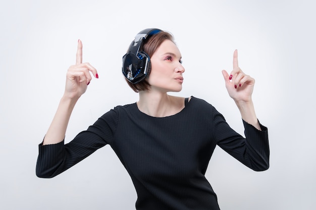 Retrato de una mujer en auriculares profesionales. Fondo blanco. Concepto de dj. Técnica mixta