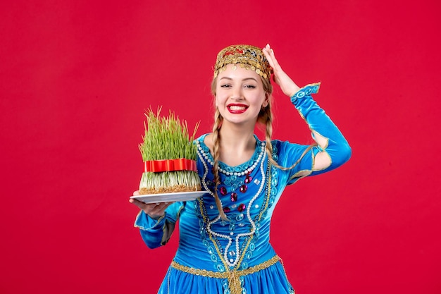 Retrato de mujer azerí en traje tradicional con estudio semeni tiro fondo rojo concepto étnico vacaciones novruz
