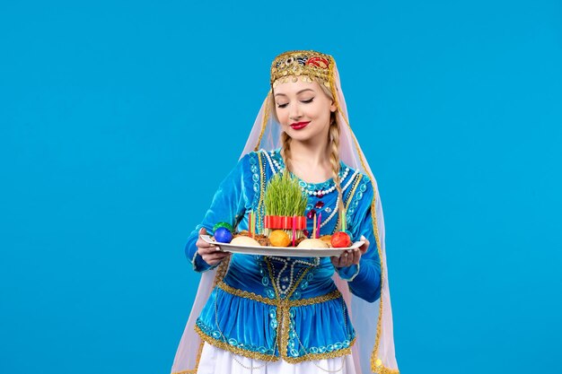 Retrato de mujer azerí en traje tradicional con novruz xonca studio shot fondo azul concepto bailarina primavera