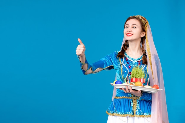 Retrato de mujer azerí en traje tradicional con xonca pared azul étnica primavera novruz