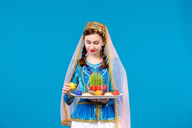 Foto retrato de mujer azerí en traje tradicional con xonca pared azul étnicos novruz primavera bailarines