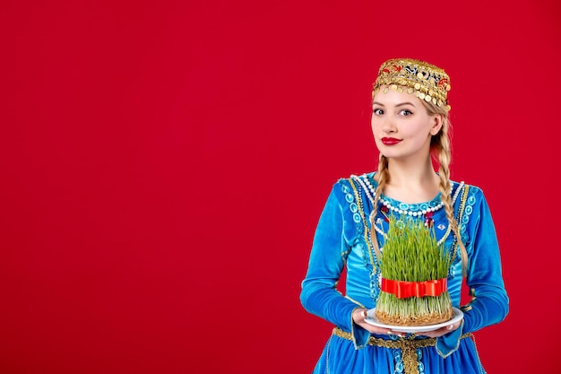 Retrato de mujer azerí en vestido tradicional sosteniendo semeni studio shot fondo rojo novruz fiesta étnica primavera