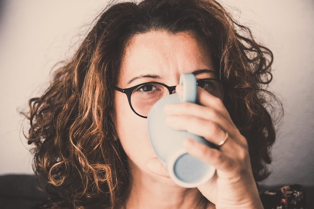 Retrato de una mujer bebiendo café en una taza