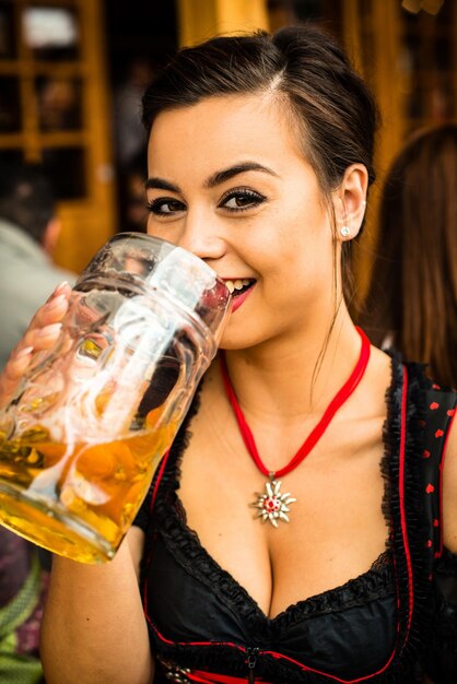 Foto retrato de una mujer bebiendo cerveza en el oktoberfest