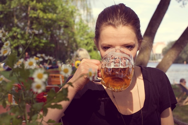 Retrato de una mujer bebiendo cerveza