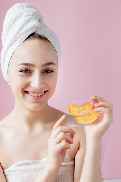 Retrato de mujer de belleza con parches en los ojos en rosa