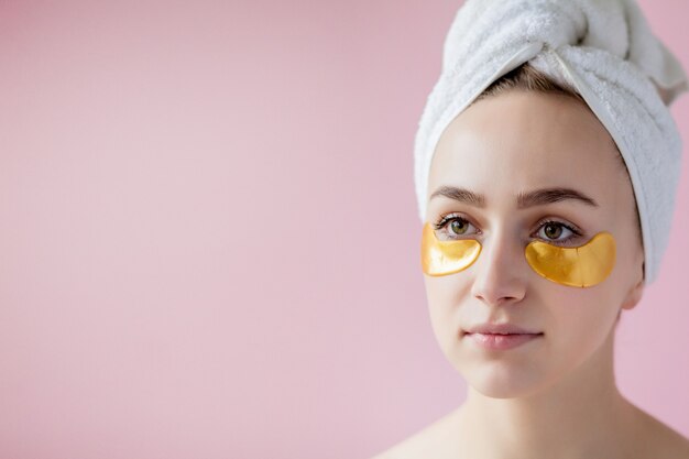 Retrato de mujer de belleza con parches en los ojos en rosa