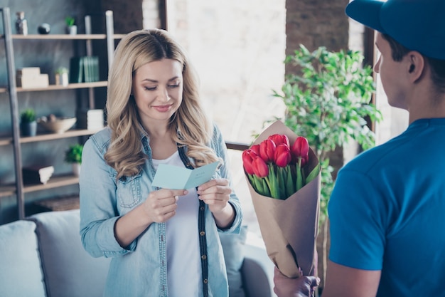 Retrato de mujer bonita adorable leer tarjeta recibir flores rojas