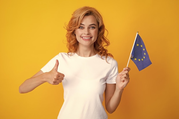 Retrato de una mujer bonita y amistosa que sostiene la bandera de la Unión Europea, símbolo de la asociación europea de la UE