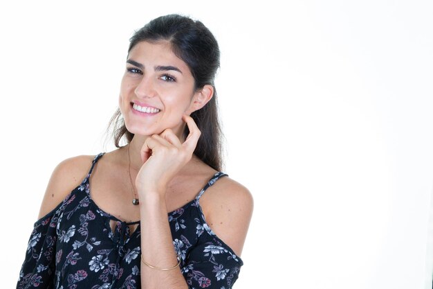 Retrato de mujer bonita chica morena sobre fondo blanco aislado sonriendo con la mano en la cara de la barbilla