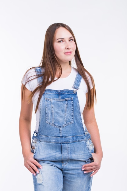 Retrato de una mujer bonita sonriente en denim en general aislado sobre fondo blanco.