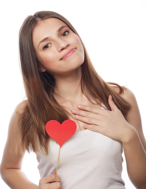 Foto retrato de una mujer bonita sosteniendo un corazón de papel