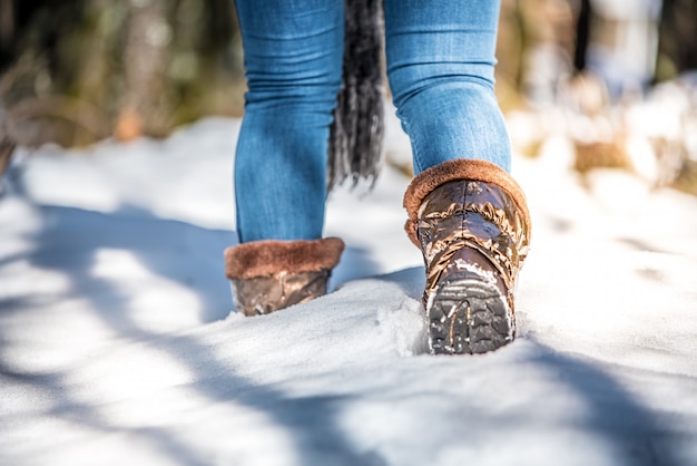 Retrato mujer botas en una carretera con nieve en invierno caminando