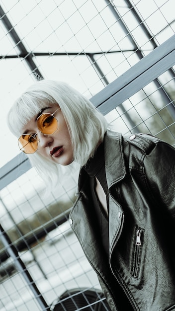 Retrato de mujer con cabello blanco y gafas. Estilo urbano moderno - foto vertical