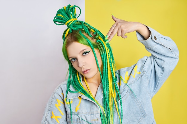 Retrato de una mujer con cabello de colores creativos en color verde y amarillo.