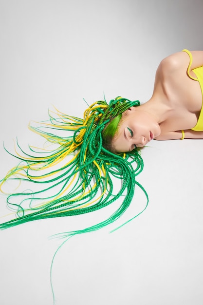 Retrato de una mujer con cabello de colores creativos en verde y amarillo