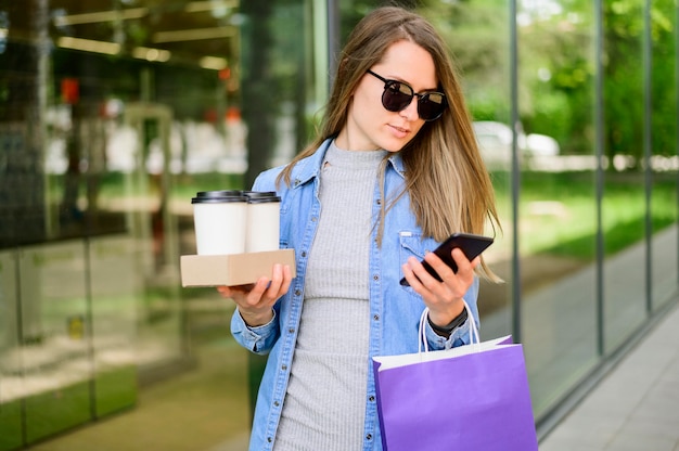 Foto retrato de mujer con café y bolsas de compras