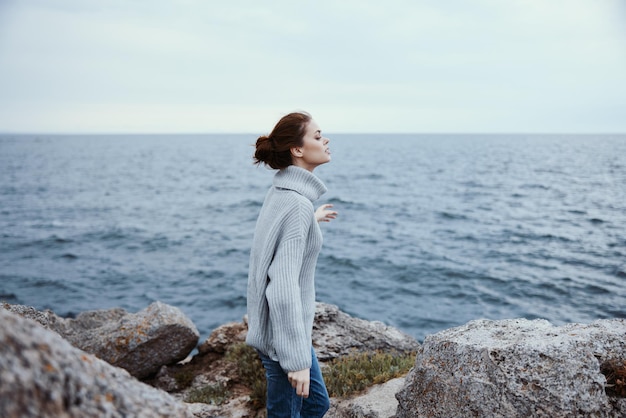 Retrato de una mujer caminando por la libertad en la costa de piedra Concepto de relajación