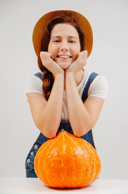 Retrato de una mujer campesina con un mono sonriente descansando sobre una gran calabaza orgánica madura