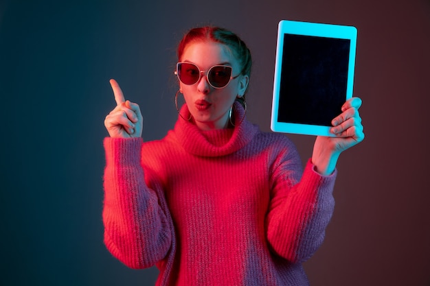 Retrato de mujer caucásica aislado sobre fondo de estudio degradado en luz de neón