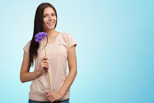 Retrato de mujer caucásica atractiva joven con una flor
