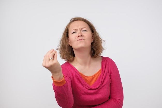 Retrato de una mujer caucásica decepcionada que frunce el ceño mostrando al italiano qué quieres gesto de estar enojado o irritado