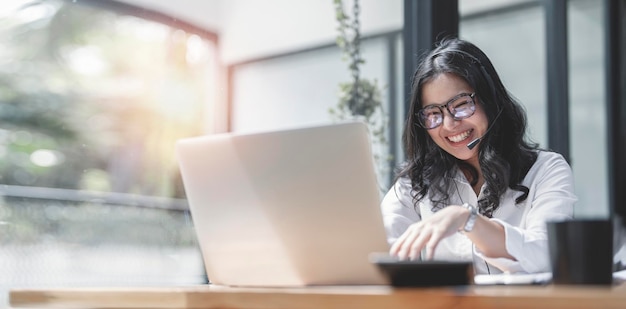 Retrato de mujer caucásica feliz despreocupada con anteojos con videollamada a través de una computadora portátil sentada en un café riendo alegremente