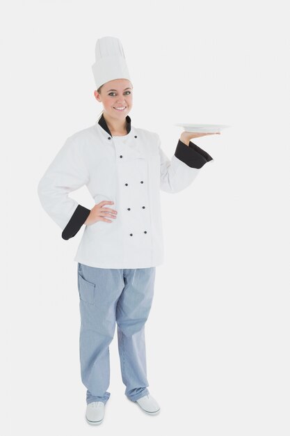 Retrato de mujer chef sosteniendo un plato vacío