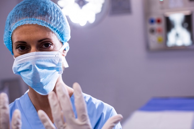 Retrato de mujer cirujana preparándose para la operación en sala de operaciones